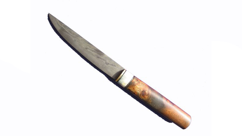 Das Messer besteht aus 2 Strängen Torsionsdamast an die eine Schneidlage aus C60 Stahl feuergeschweißt wurde. Der Griff besteht aus geölter Maserrüster (Ulmenholz) mit Messing- Geweihverzierung.